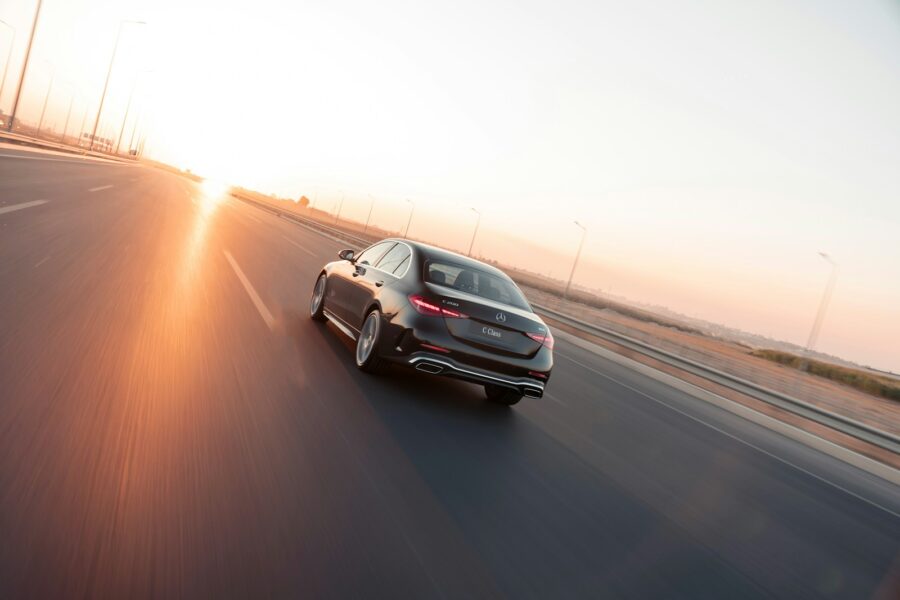 Electric car driving highway sunset
